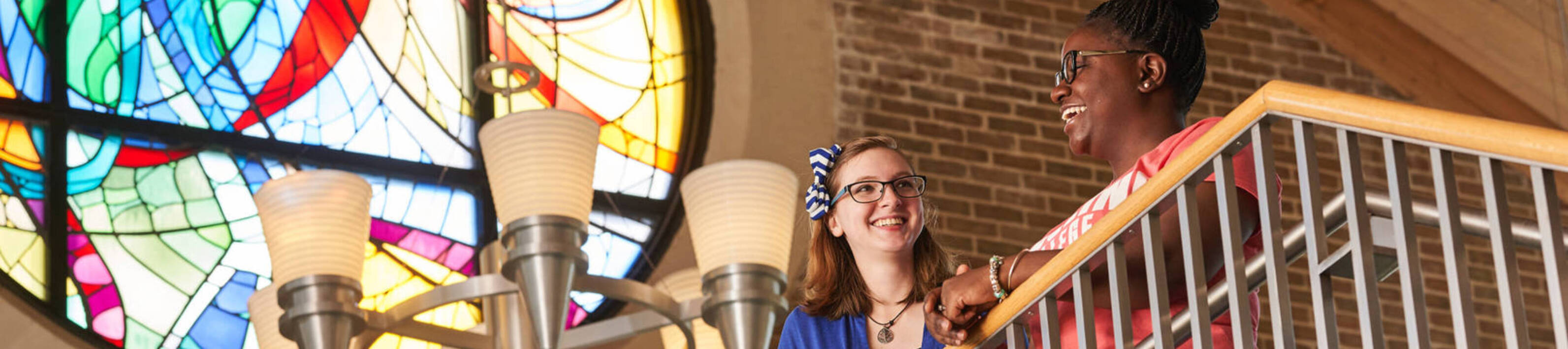 Ursuline college two women smiling on balcony